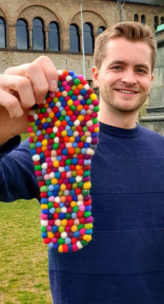 Eine Person h�lt bunte Einlegesohlen aus Wolle in der Hand